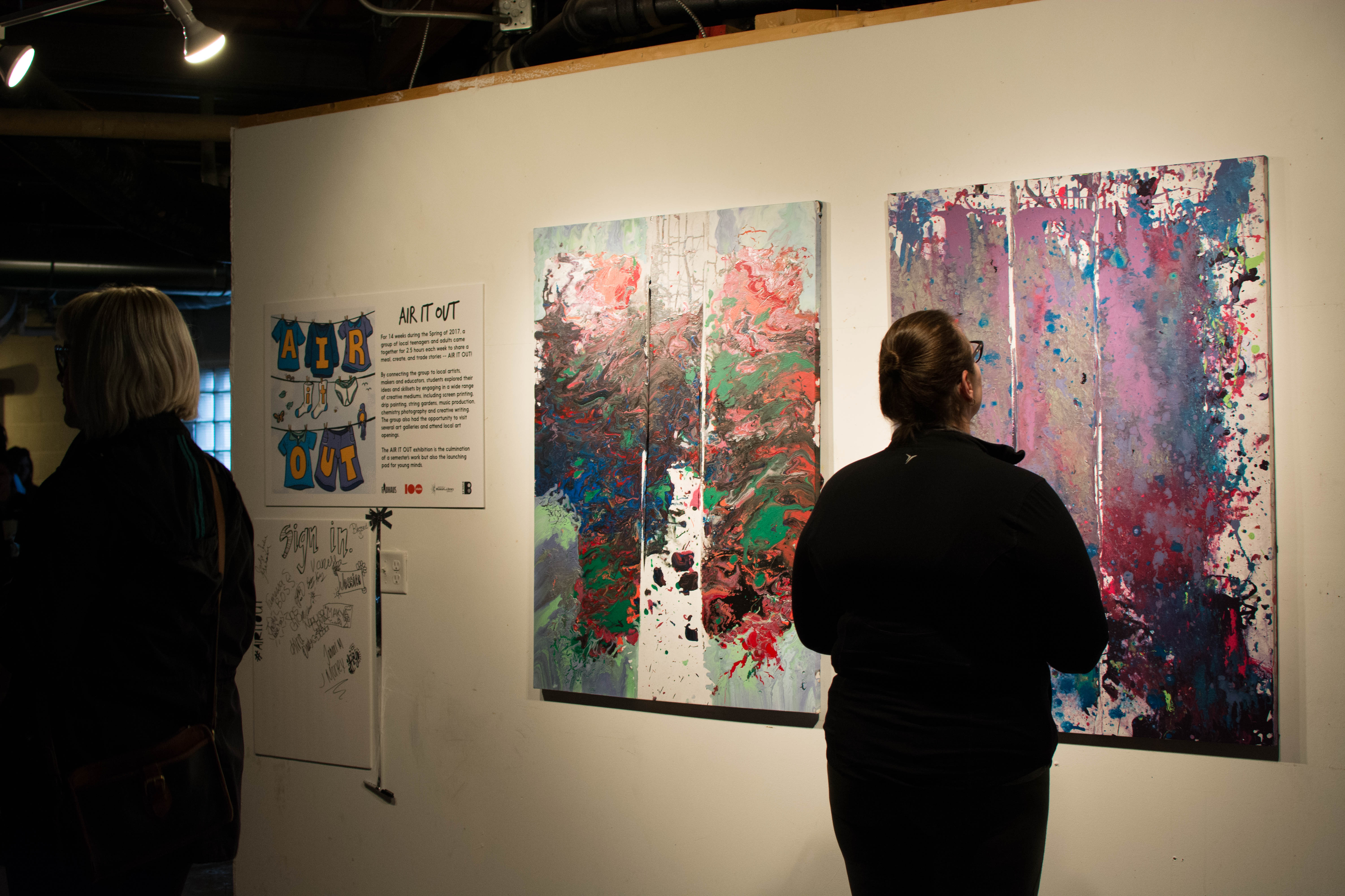 picture of someone viewing drip paintings at Air It Out teen art exhibition