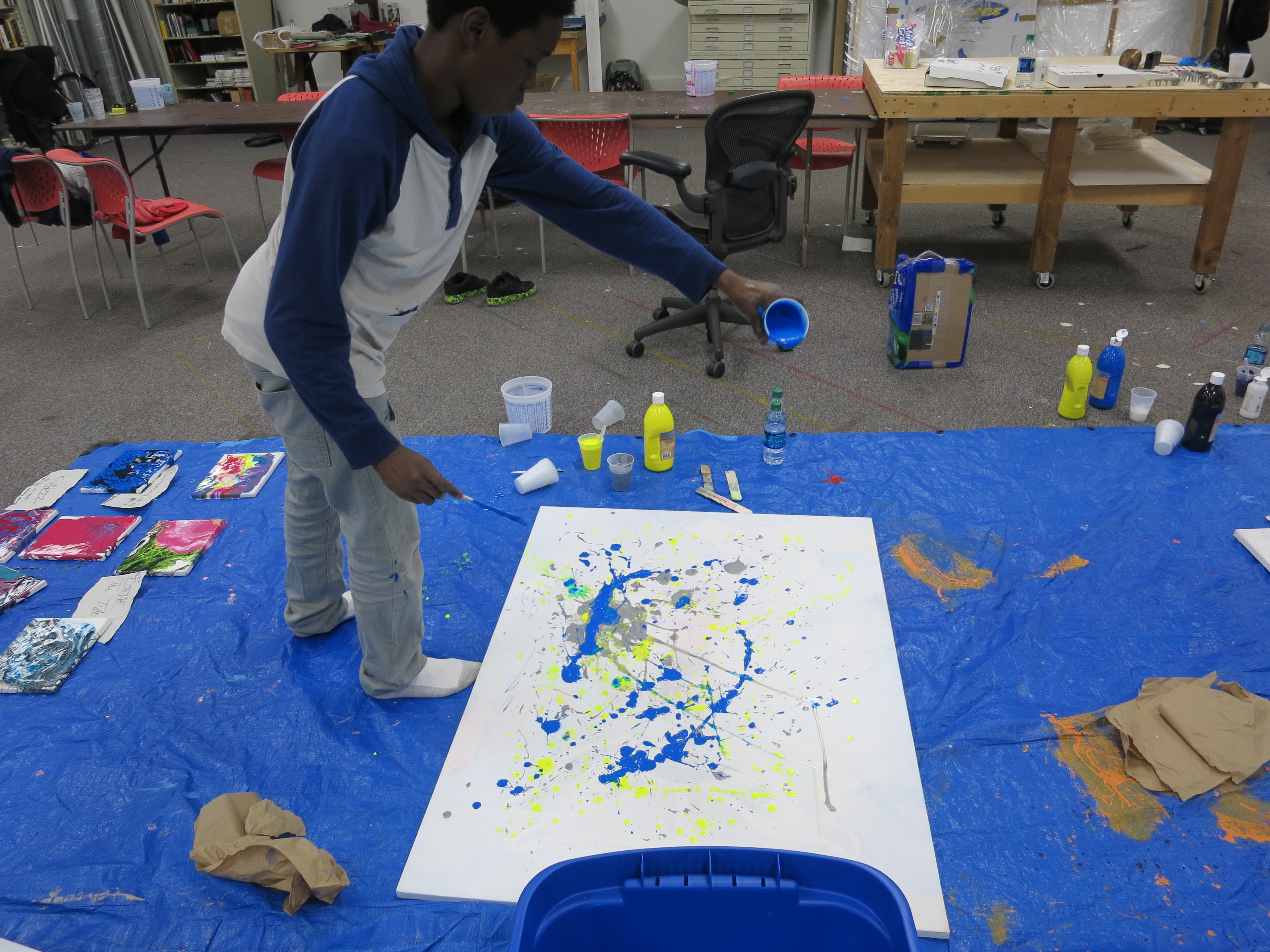 picture of teens creating drip paintings during Air It Out semester of art