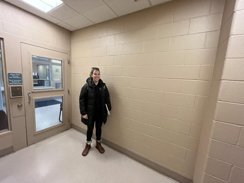 Artist Maria Schirmer standing next to the blank wall at the public entrance to Dane County Juvenile Detention Center